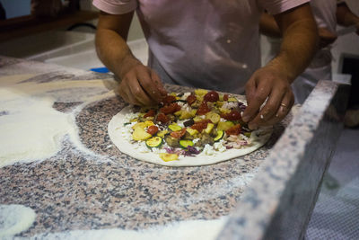 Midsection of man preparing food in kitchen