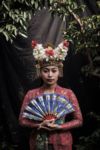 Portrait of woman in traditional clothing against tree