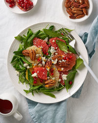 Top view fruits citrus salad with nuts, green lettuce leaves. balanced food. spinach  