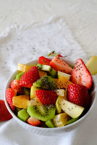 Closeup view of bowl of healthy fresh fruit salad and chia seeds