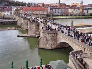 People on bridge over river in city