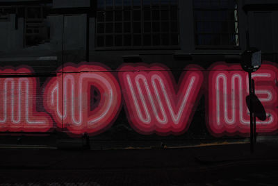 Red text on illuminated building at night