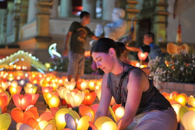 People sitting in illuminated traditional clothing at night