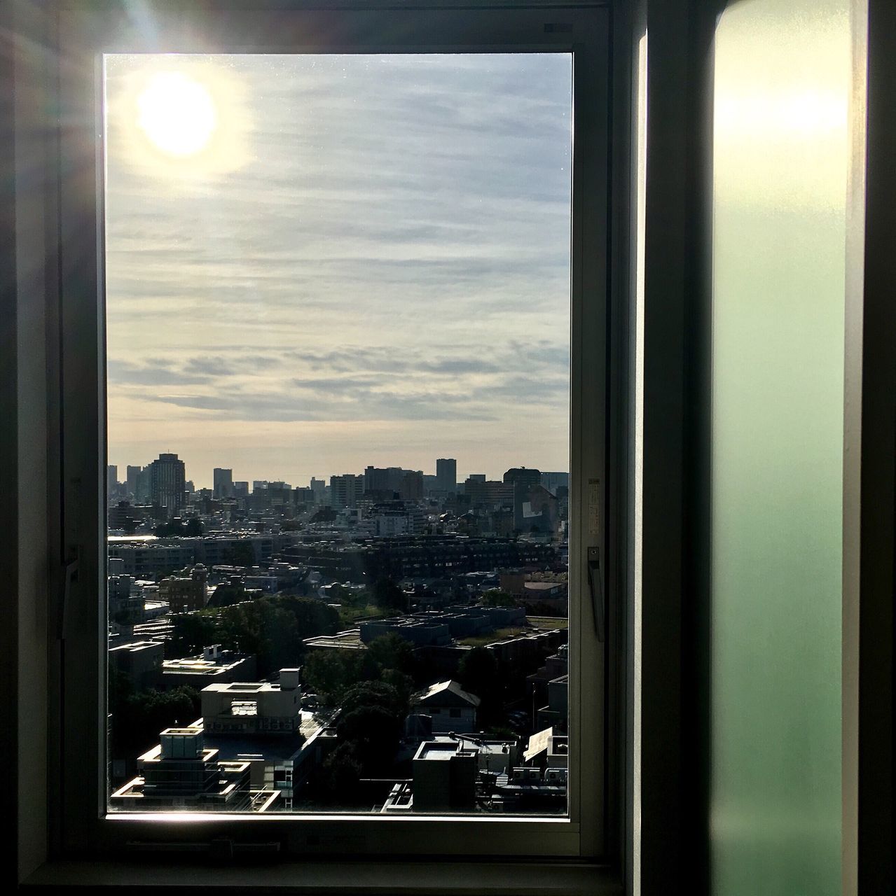 AERIAL VIEW OF CITYSCAPE SEEN THROUGH WINDOW