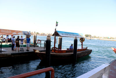 People on boat in canal against clear sky