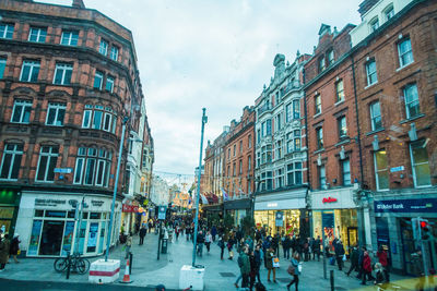 Panoramic view of people in city against sky