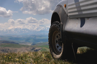 Suv wheel on the off-road adventure trail against the backdrop of mountains in the clouds