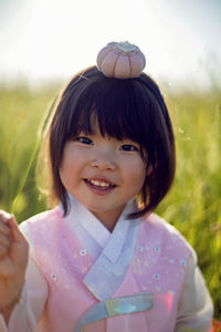 Korean national children pink costume on a four year old girl standing in a field with grass