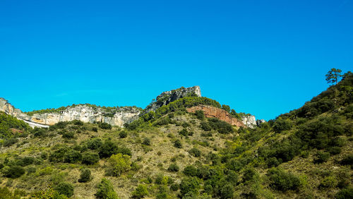 Low angle view of mountain against clear blue sky