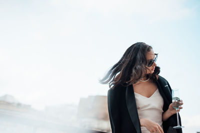 Woman looking at camera against sky