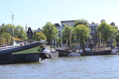 Boats moored in river against sky