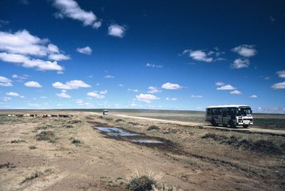 Buses on landscape against sky