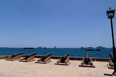 Sailboats on sea against clear blue sky