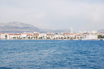 Townscape by sea against sky in city