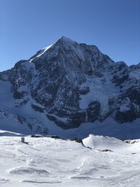 Scenic view of snowcapped mountains against clear sky
