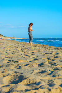 Full length of man standing on beach against sky