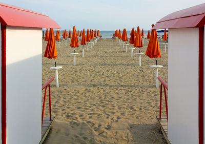 Deck chairs on beach against clear sky