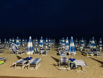 Panoramic view of chairs at beach against blue sky