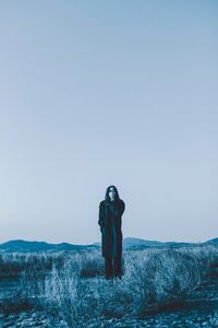 Man photographing at camera against clear sky