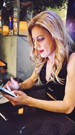 Woman using mobile phone while sitting outdoors