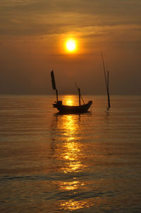 Boat sailing on sea against sky during sunset