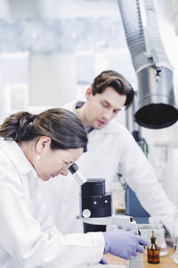 Female scientist using microscope at laboratory