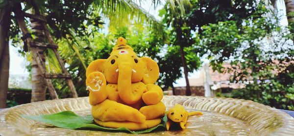 Close-up of stuffed toy against trees