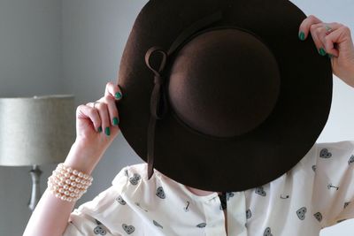 Close-up of woman holding hat