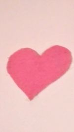 Close-up of red heart shape on white background