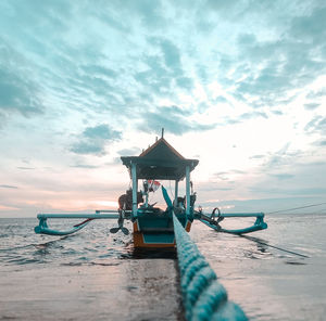 Lifeguard hut on beach against sky during sunset