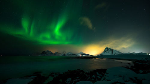 Scenic view of snowcapped mountains against sky at night