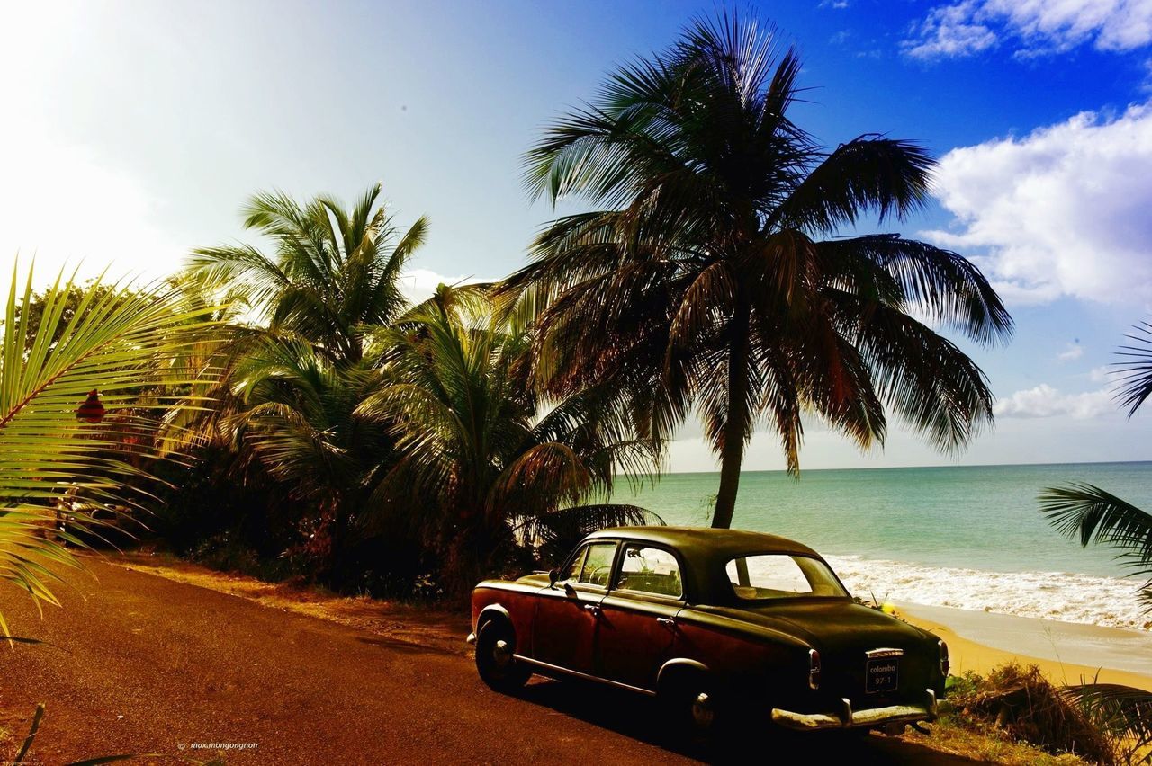 CARS ON BEACH AGAINST SKY