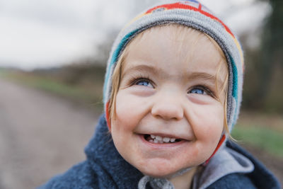 Close-up of smiling girl looking up