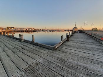 Pier over river in city against clear sky