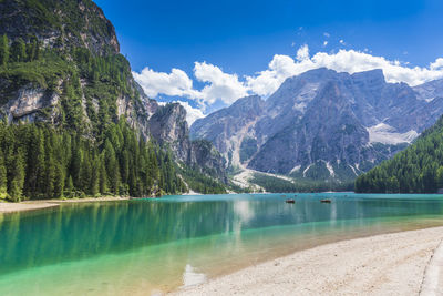 Scenic view of lake by mountains against sky