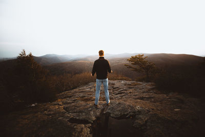 Rear view of man looking at mountain against sky