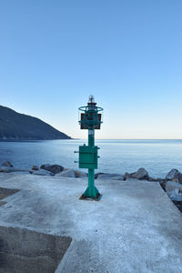 Lifeguard hut on beach against clear blue sky