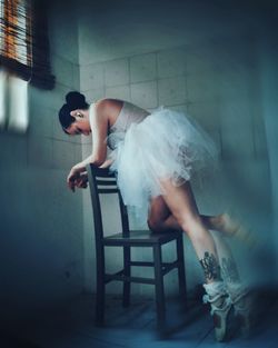 Ballet dancer dancing on chair at home