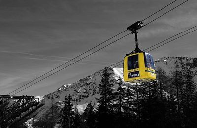 Low angle view of overhead cable car against sky