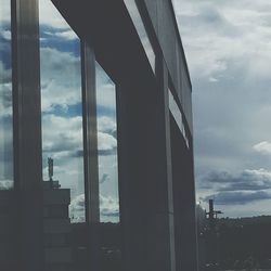 Close-up of cityscape against sky seen through window