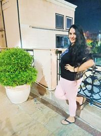 Portrait of smiling woman standing against building