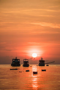 View of fishing boats in sea during sunset