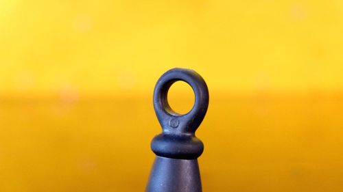 Close-up of coin-operated binoculars against yellow background