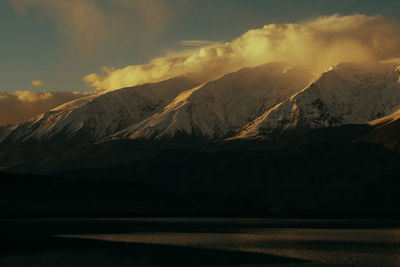 Scenic view of snowcapped mountains against sky during sunset