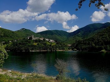 Scenic view of lake by mountains against sky