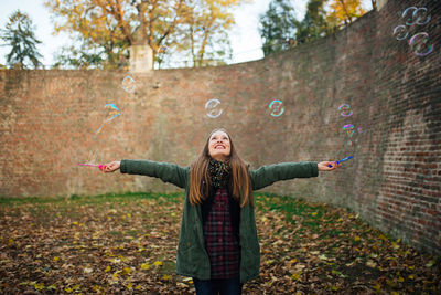 Happy young woman standing at park