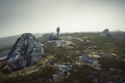 Man walking in foggy landscape