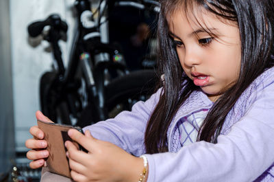 Close-up of cute girl using smart phone