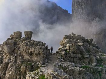 Panoramic view of people on rock formation against sky