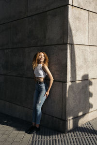 Portrait of woman standing against wall